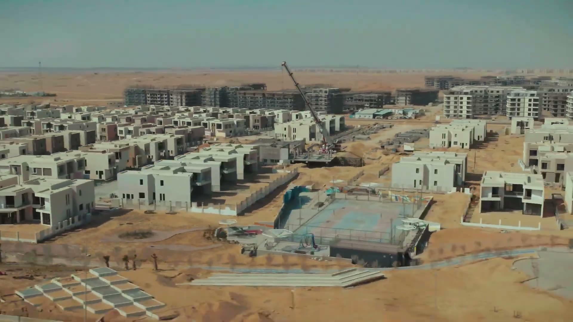 Aerial of Badya's first district under construction with open desert behind