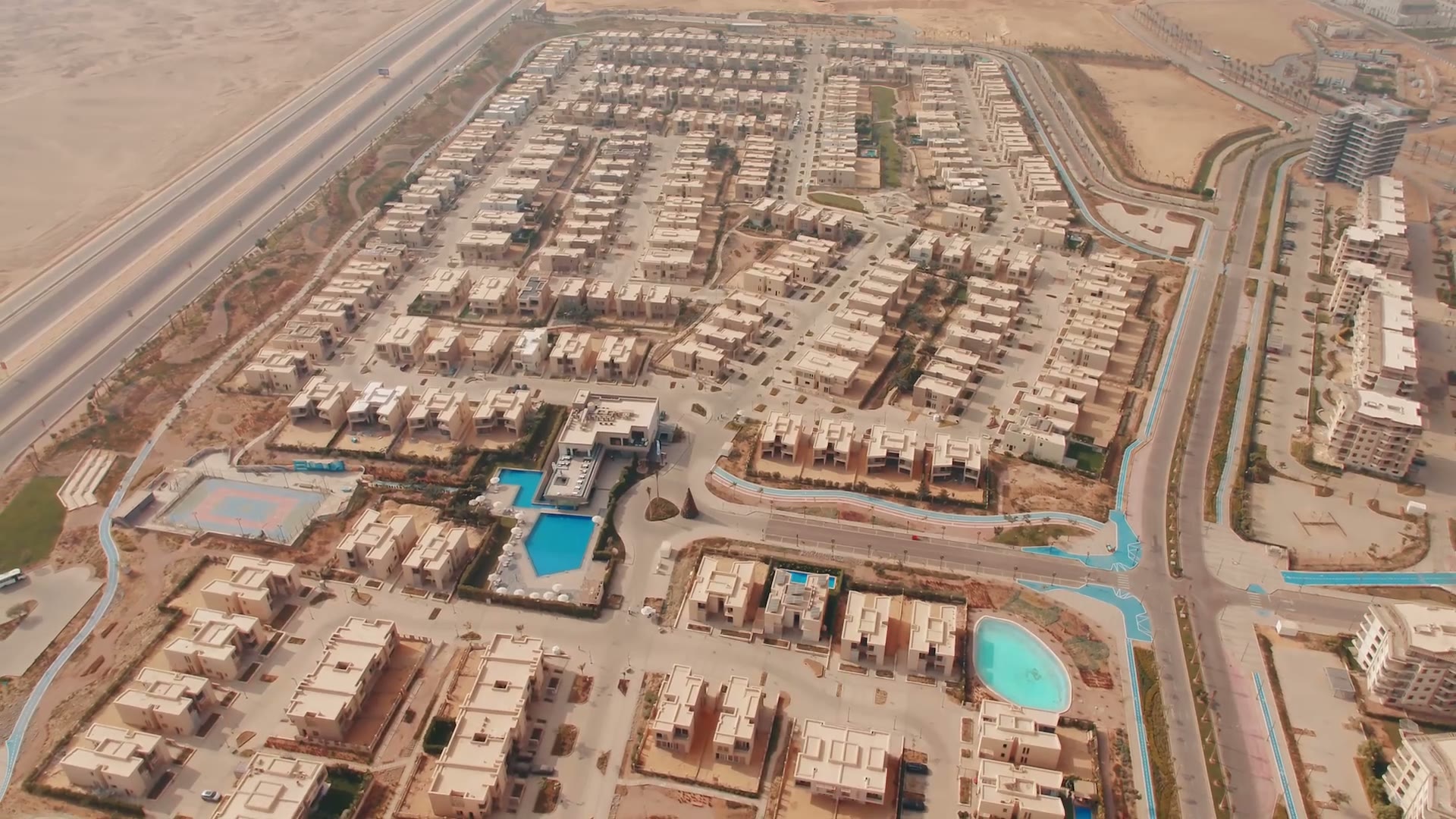 Aerial of finished Badya villas around a lagoon and pools